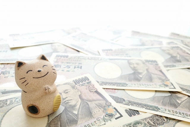 1万円札と笑顔の招き猫